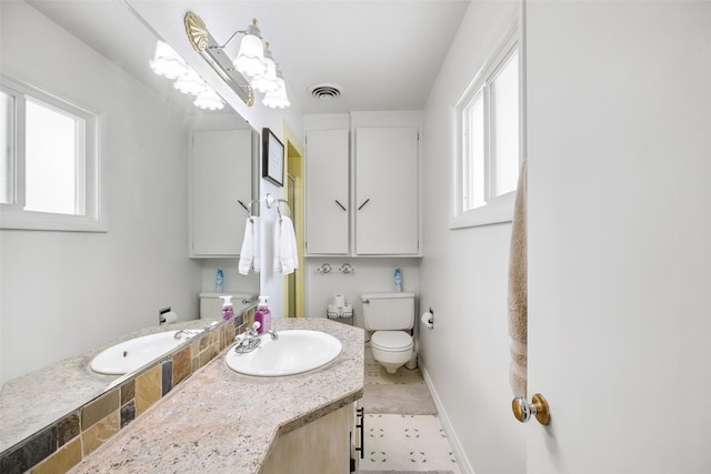 bathroom featuring baseboards, visible vents, vanity, and toilet