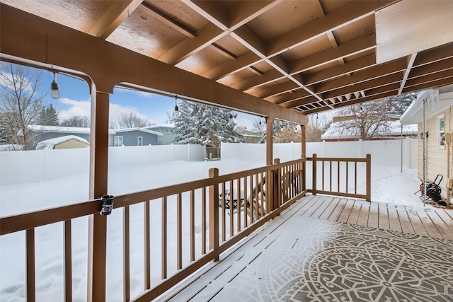 snow covered deck featuring a fenced backyard