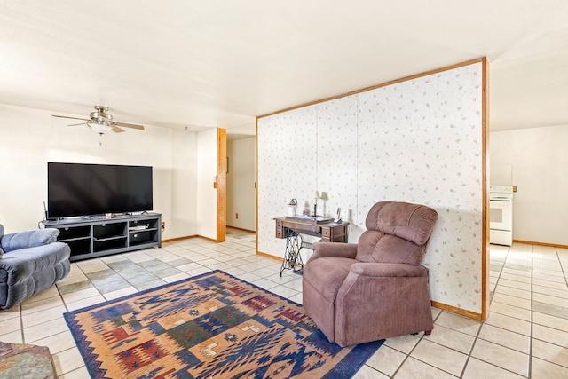 living area featuring a ceiling fan, baseboards, and light tile patterned floors