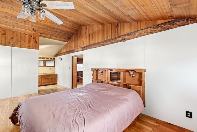 bedroom with lofted ceiling with skylight, wooden ceiling, connected bathroom, and light wood-style flooring