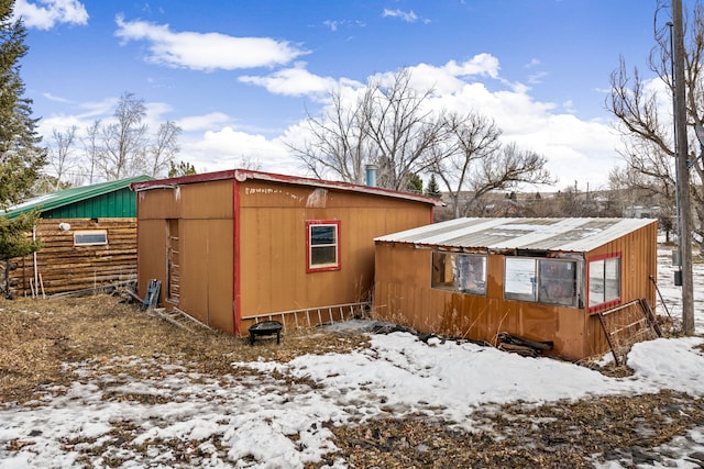 view of snowy exterior featuring metal roof