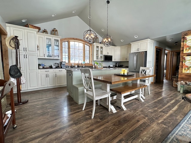 kitchen with appliances with stainless steel finishes, dark countertops, glass insert cabinets, and dark wood-style floors