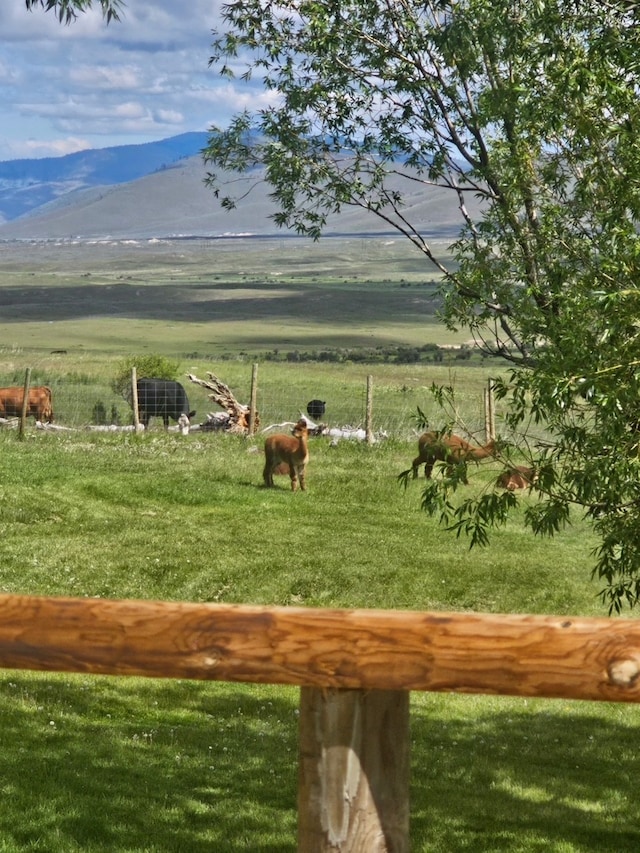 view of community with a yard, a rural view, and a mountain view