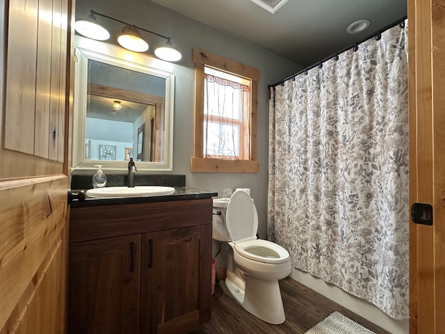 full bath featuring wood finished floors, a shower with shower curtain, vanity, and toilet