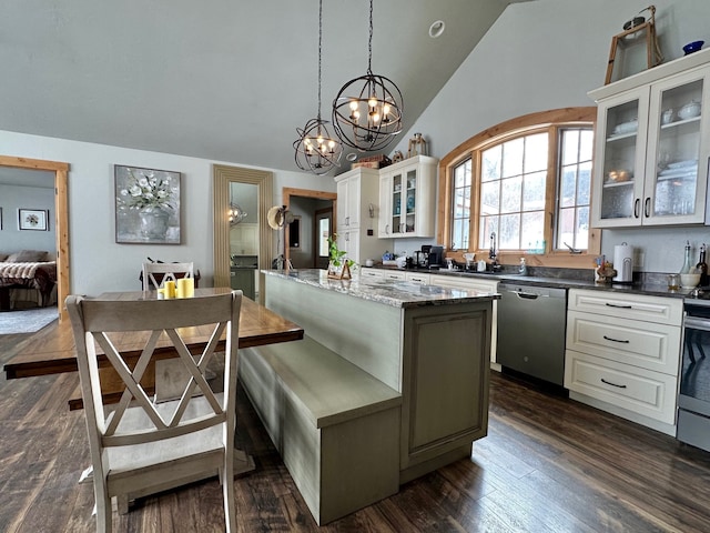 kitchen featuring dark wood-style floors, a kitchen island, vaulted ceiling, and stainless steel dishwasher