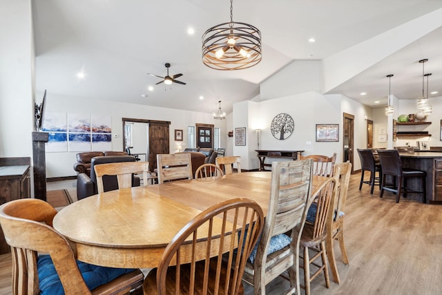 dining area with lofted ceiling, recessed lighting, ceiling fan with notable chandelier, and light wood-style floors