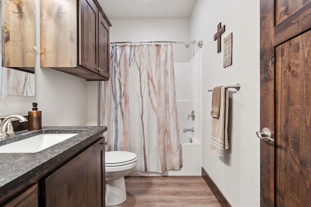 full bathroom featuring toilet, shower / bath combo, vanity, wood finished floors, and baseboards