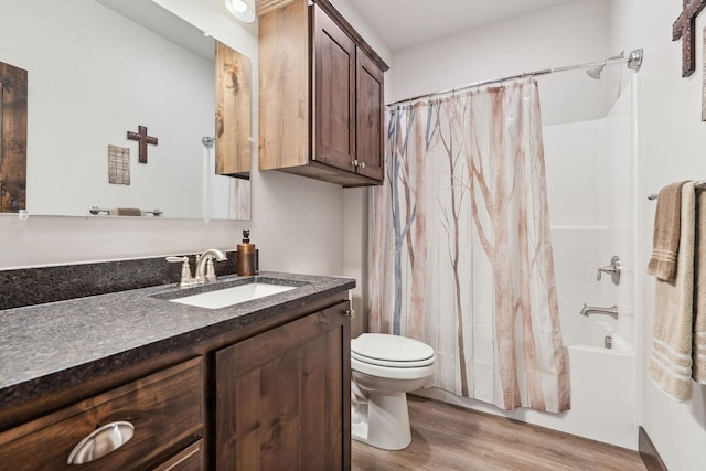 full bath with toilet, shower / bathtub combination with curtain, vanity, and wood finished floors