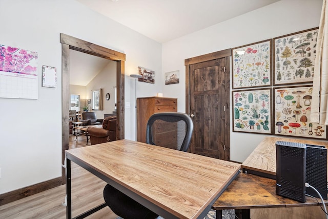 home office featuring vaulted ceiling, wood finished floors, and baseboards