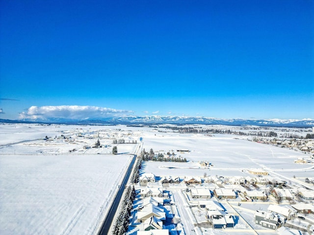 snowy aerial view featuring a residential view and a mountain view