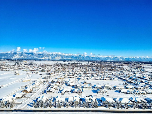 snowy aerial view featuring a residential view and a mountain view