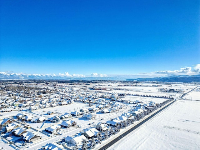 snowy aerial view with a residential view and a mountain view