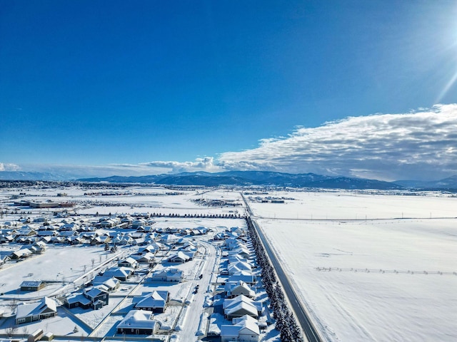 snowy aerial view featuring a residential view and a mountain view