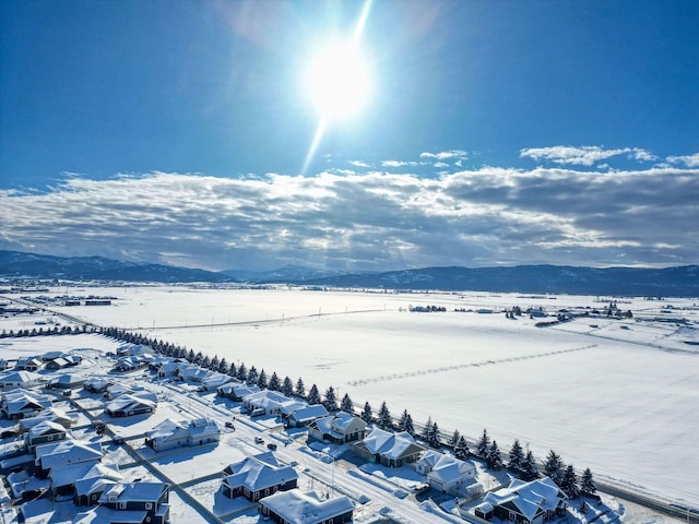 snowy aerial view featuring a residential view and a mountain view