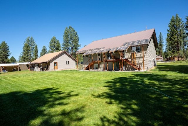 back of house with metal roof, stairway, and a lawn