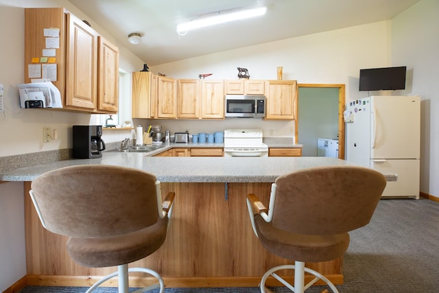 kitchen featuring light brown cabinets, white appliances, a kitchen breakfast bar, vaulted ceiling, and light countertops