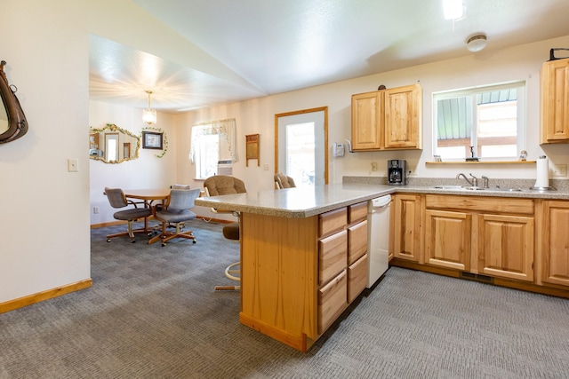 kitchen featuring a peninsula, light countertops, a wealth of natural light, carpet, and pendant lighting