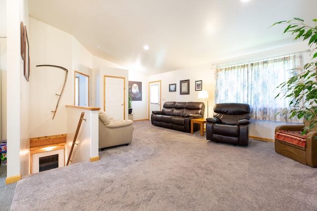 living area with vaulted ceiling, baseboards, and light colored carpet