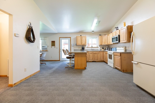 kitchen with lofted ceiling, light countertops, light brown cabinets, white appliances, and a kitchen bar