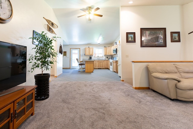 living room featuring light carpet, ceiling fan, baseboards, and vaulted ceiling