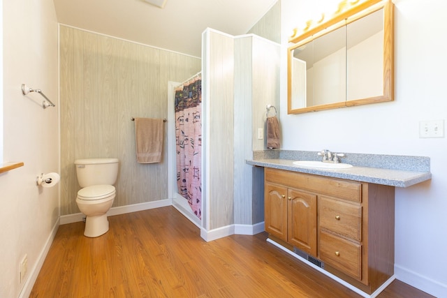 full bath featuring toilet, a stall shower, wood finished floors, and vanity