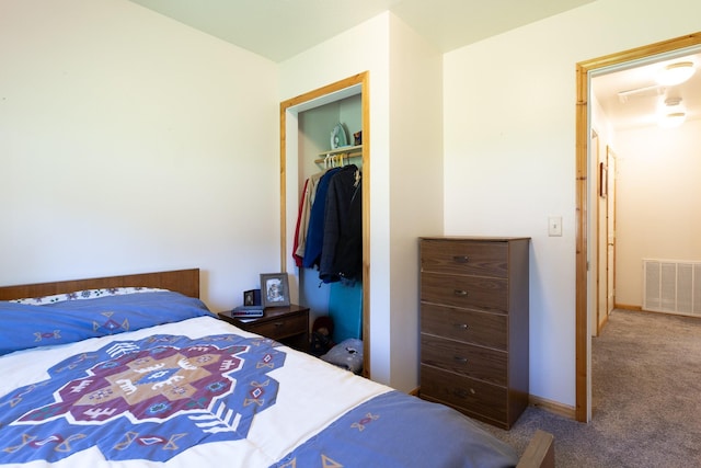 carpeted bedroom with a closet, visible vents, and baseboards