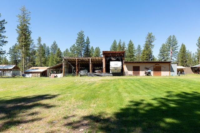 view of yard featuring an outbuilding, a pole building, and a carport