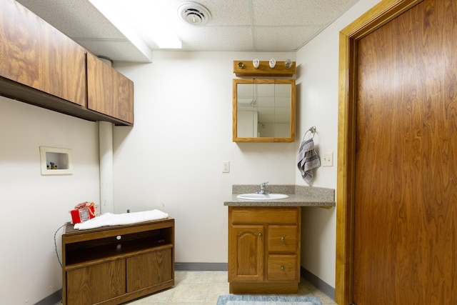 bathroom featuring visible vents, a drop ceiling, vanity, and baseboards