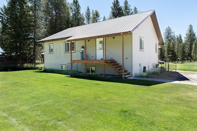 view of front of house featuring a front yard, metal roof, and stairway