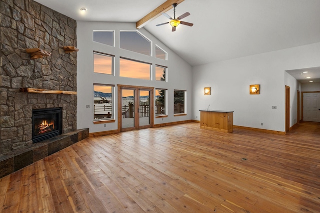 920 Antelope Ridge Rd, Belgrade, MT 59714 - unfurnished living room with beam ceiling, high vaulted ceiling, hardwood / wood-style flooring, a fireplace, and ceiling fan