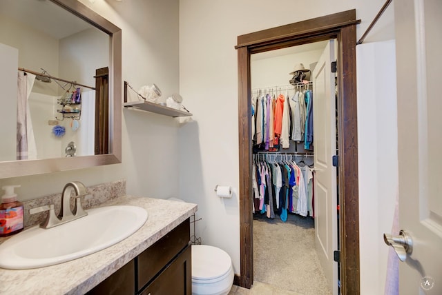 full bathroom with toilet, a walk in closet, vanity, and a shower with curtain