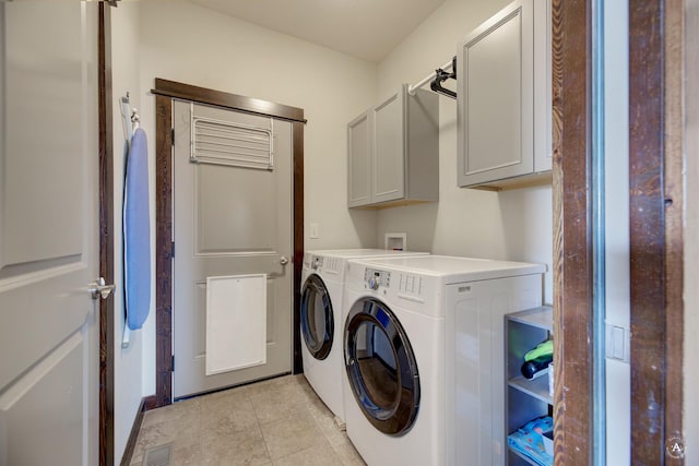 laundry area featuring light tile patterned floors, cabinet space, visible vents, and separate washer and dryer