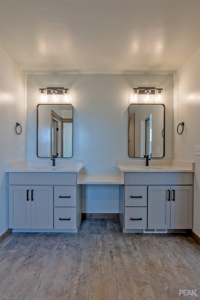 bathroom featuring vanity, baseboards, and wood finished floors