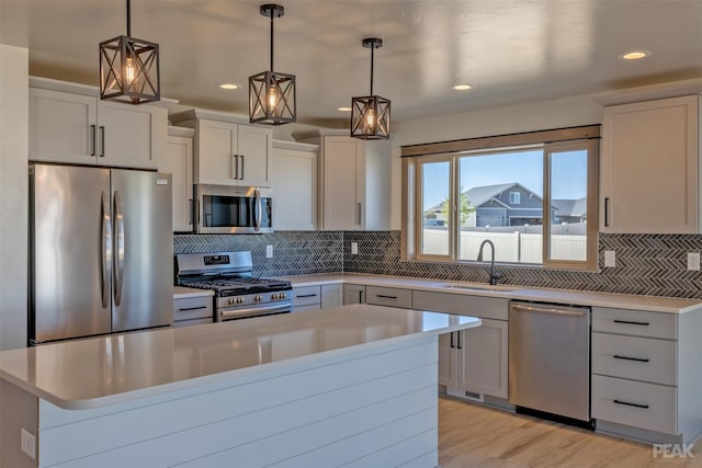 kitchen featuring pendant lighting, stainless steel appliances, and light countertops