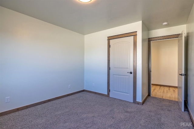 unfurnished bedroom featuring carpet flooring and baseboards