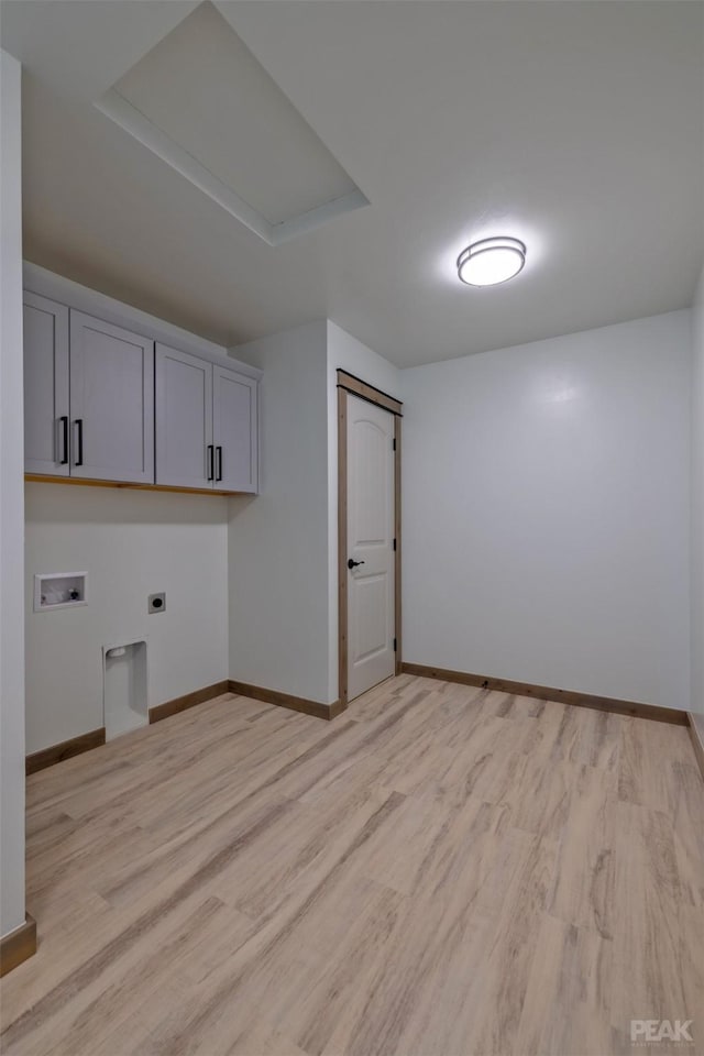 washroom featuring hookup for a washing machine, light wood-style flooring, hookup for an electric dryer, baseboards, and cabinet space