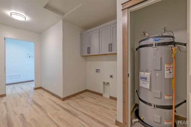 laundry area with hookup for an electric dryer, visible vents, water heater, cabinet space, and light wood finished floors