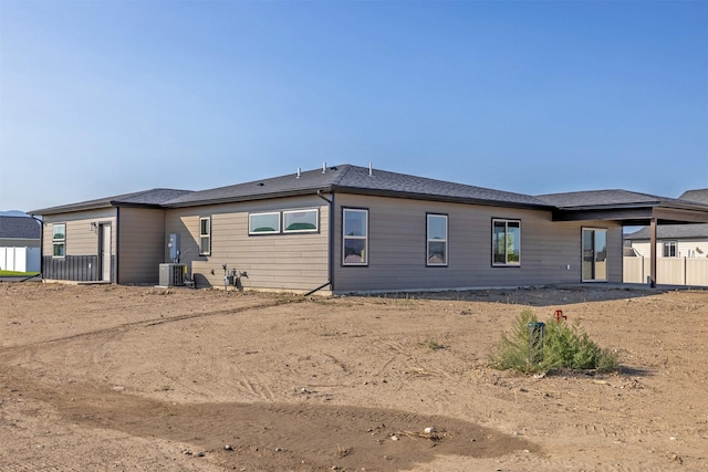 rear view of property featuring central AC and fence