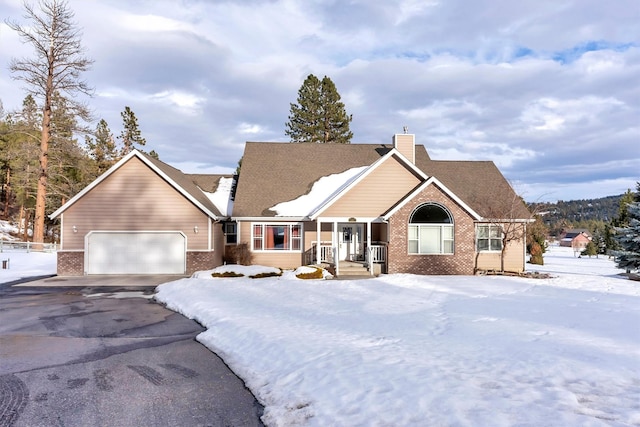 ranch-style house with a garage, a chimney, aphalt driveway, and brick siding