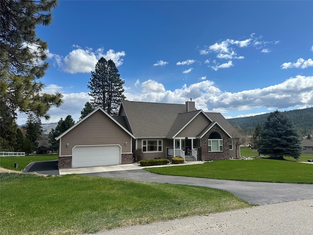 craftsman house featuring brick siding, a front yard, a garage, and aphalt driveway