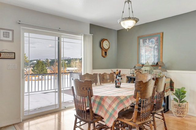 dining room featuring a wainscoted wall and light wood-style floors