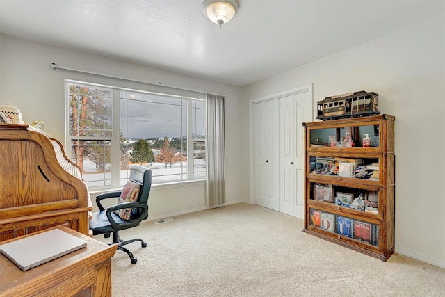 carpeted office featuring visible vents and baseboards