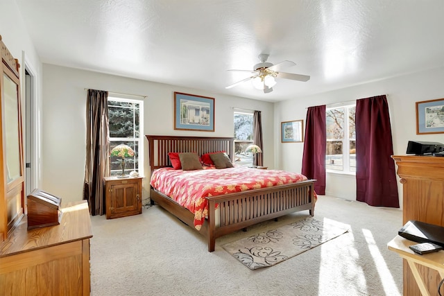 bedroom featuring light colored carpet and ceiling fan