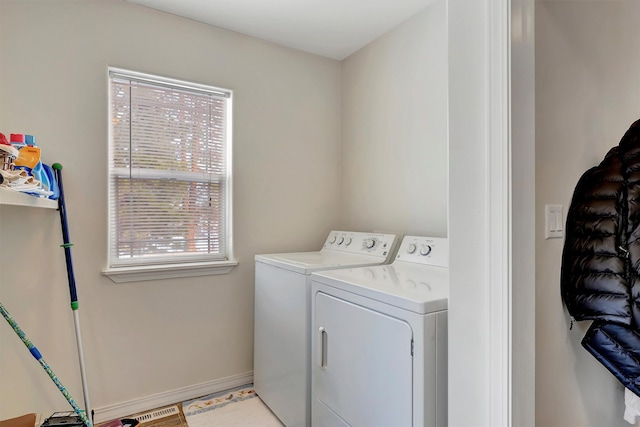 washroom with baseboards, laundry area, and washer and dryer