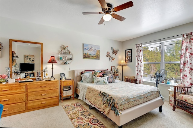 bedroom with carpet floors, a textured ceiling, and a ceiling fan