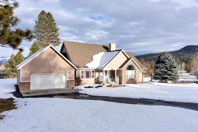 view of front of house with a garage, a chimney, a mountain view, and brick siding