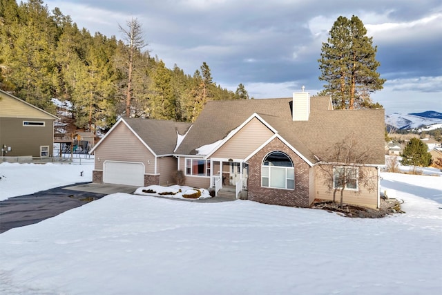 view of front facade featuring a garage, brick siding, a chimney, and aphalt driveway