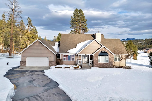 view of front facade featuring driveway, brick siding, a chimney, and an attached garage