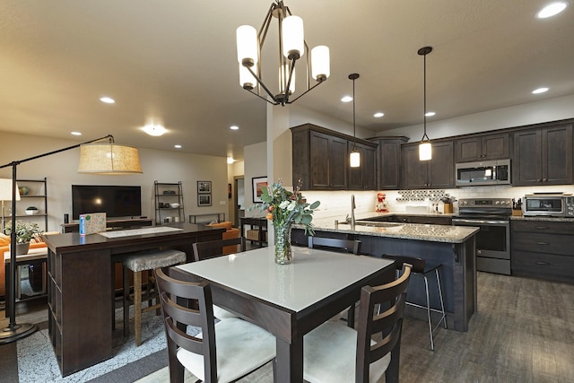 kitchen featuring a sink, stainless steel appliances, dark brown cabinets, and decorative light fixtures