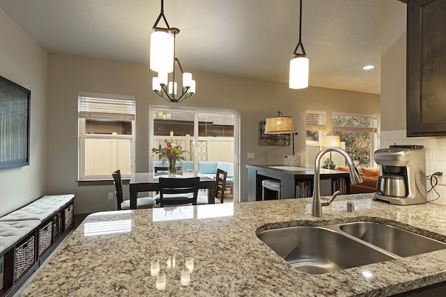 kitchen with hanging light fixtures, a sink, and a healthy amount of sunlight